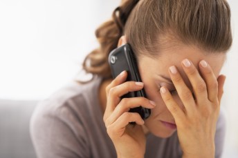 Stressed young woman talking mobile phone